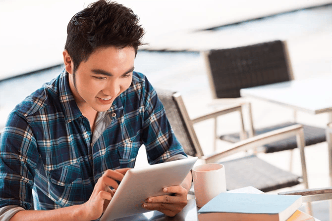 Man looking interested at what he is seeing on his tablet.