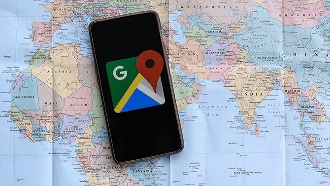 Image of mobile phone with a Google Map logo placed on top of a world map