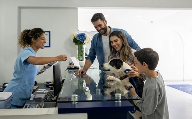 Family brings their pet in the vet for pet care, and is welcomed by staff