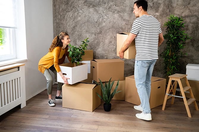 Couple carrying boxes into their new home