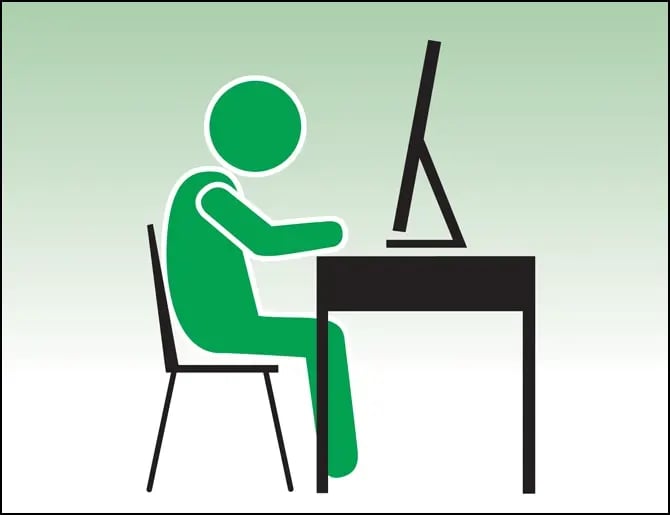 Man sitting at desk, looking at his computer monitor