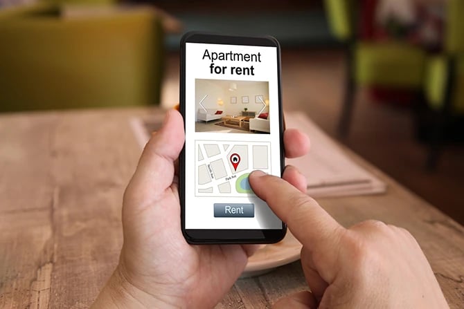 Mobile phone showing search results on an apartment marketing website.