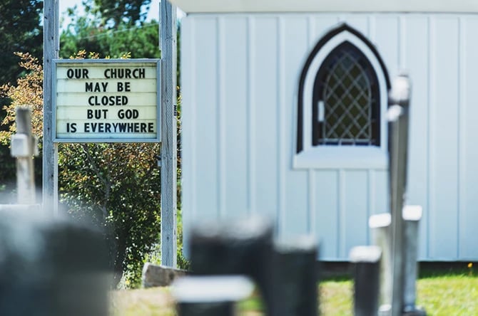 Church photo with a sign that says Our church may be closed but God is everywhere