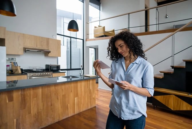 Photo of a woman at home reading her direct mailers.