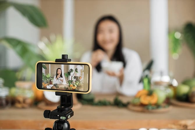 Young salon marketing content creator in white bathrobe recording beauty and wellness tips for digital marketing.