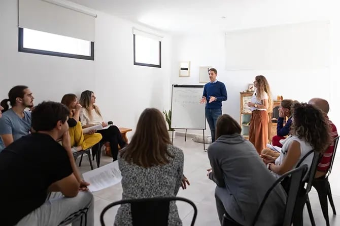Mindfulness and yoga teachers explaining breathing techniques in a group class.