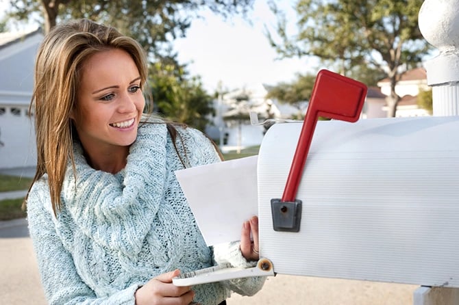 Woman taking out mail from her mailbox