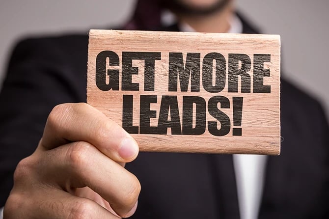 Businessman holding a Get More Leads sign.