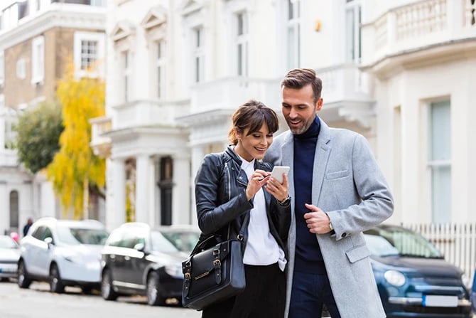 Couple looking around in the city street for real estate or luxury apartment while checking Google map.