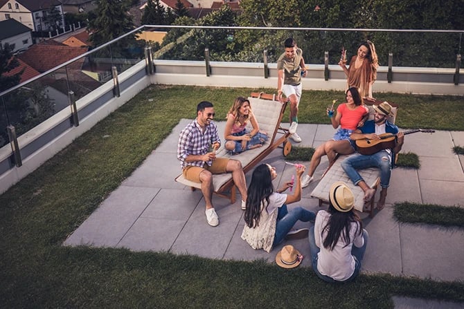 Top view of a large group of current residents having fun during a party on an apartment terrace.