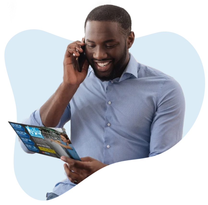 Man _On_Phone_Holding_A_Direct_Mail_Postcard